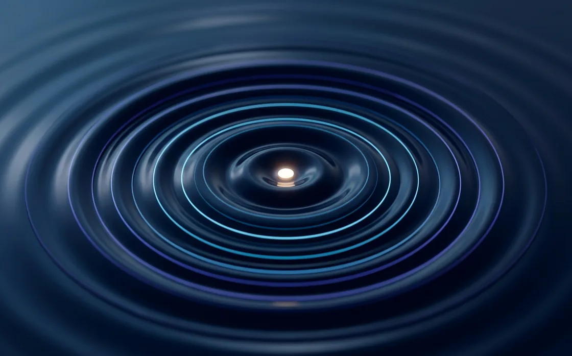 Concentric rings of light radiating from a single bright point on a dark navy surface.